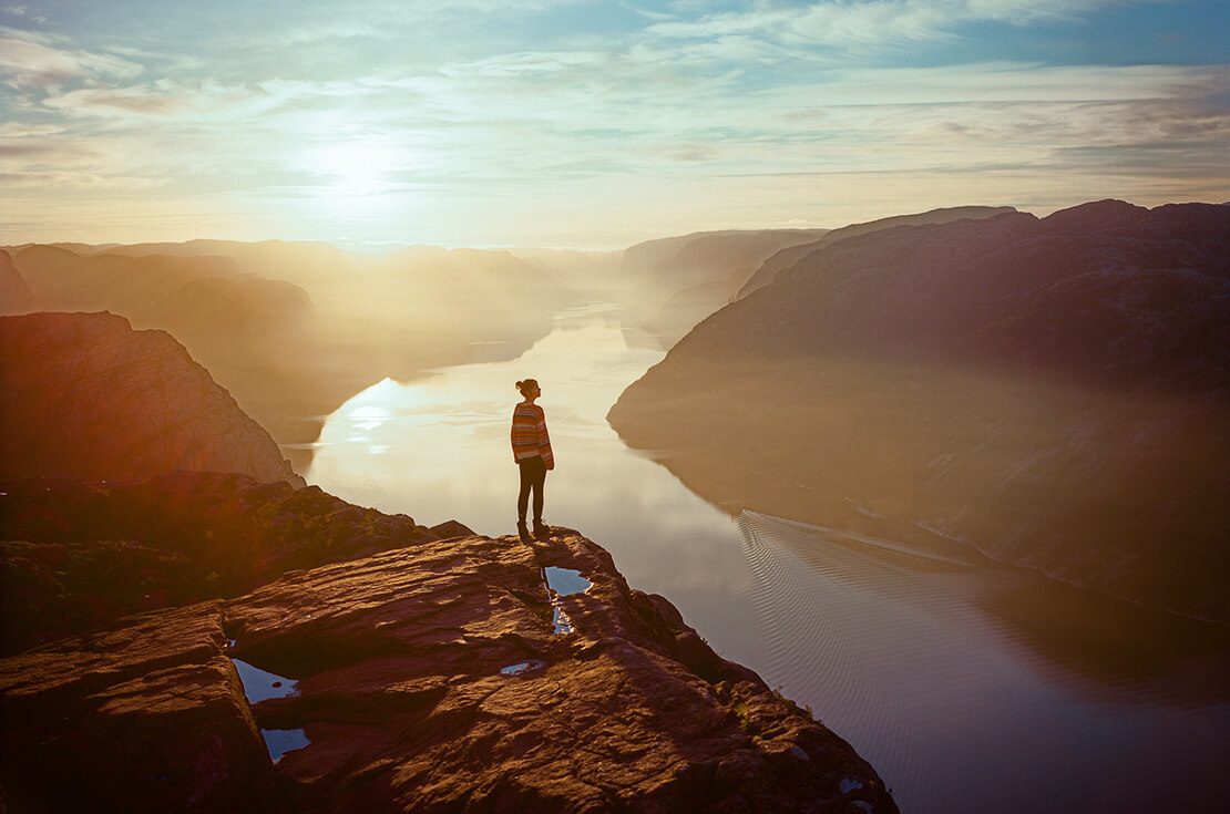 Young Caucasian woman hiking in mountains on the background of Lysefjorden