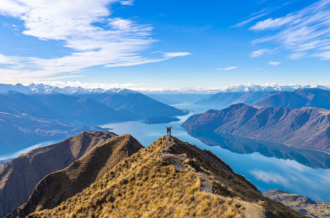 Young Asian couple celebrating success at Roy's Peak Lake Wanaka New Zealand